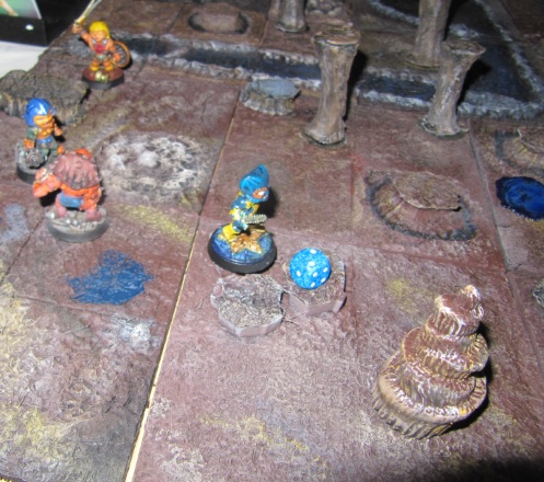 Painted fantasy miniatures and a die on a dungeon board
