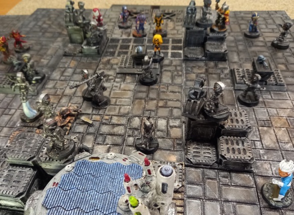A crowded industrial tabletop battlefield with painted miniatures