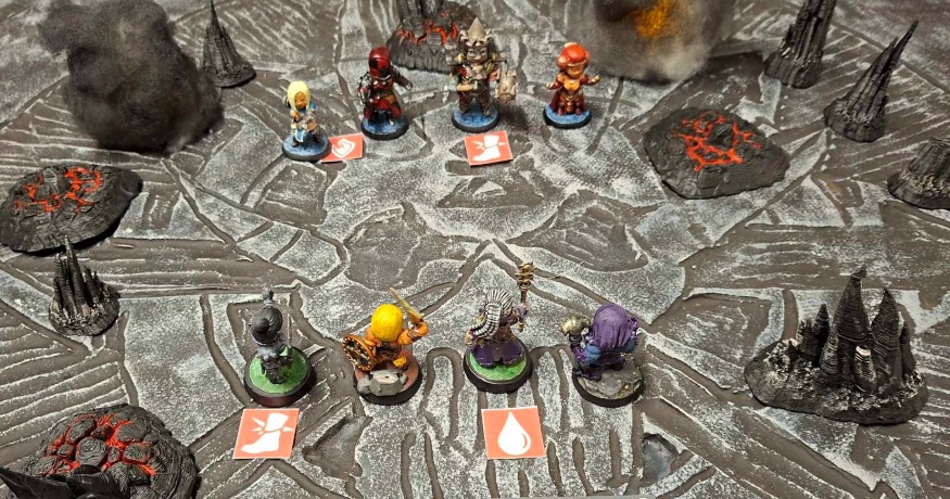 Painted miniatures facing each other across a volcanic arena